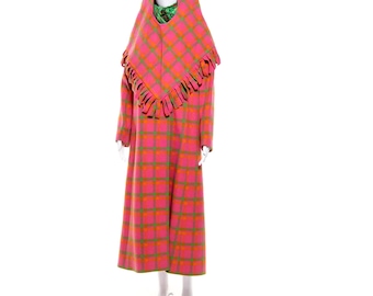 May include: A vintage pink and orange plaid coat with a matching hood and ruffled trim. The long coat features a full-length design and is displayed on a mannequin. The hood has a circular opening for the face and a green scarf is visible.
