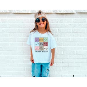 May include: White t-shirt with a colorful graphic of Harry Potter symbols and the text "In my Harry Potter Era".