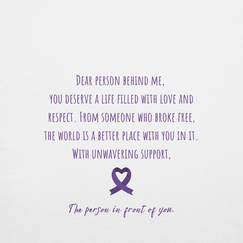 May include: Purple text on a white background with a purple ribbon in the shape of a heart. The text reads: "Dear person behind me, you deserve a life filled with love and respect. From someone who broke free, the world is a better place with you in it. With unwavering support, The person in front of you."