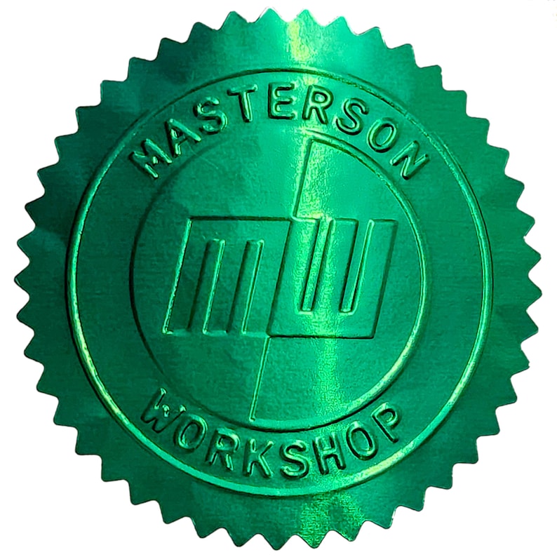 以下が含まれることがあります： 中央のロゴを囲む「MASTERSON WORKSHOP」の文字が入った、光沢のある緑色のシール。ロゴは3本の縦線と1本の横線で構成されています。シールはギザギザの星のような縁取りがされています。