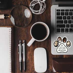 May include: A laptop computer with a paw print sticker that says "The road to my heart is paved with paw prints". The sticker has photos of dogs in each paw print.