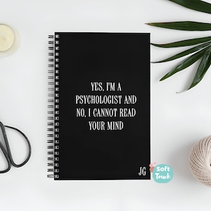 May include: Black spiral bound notebook with the text "YES. I'M A PSYCHOLOGIST AND NO, I CANNOT READ YOUR MIND" in white lettering. The notebook has the initials "JG" in the bottom right corner.