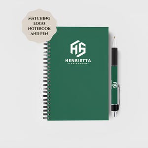 Puede incluir: Una libreta verde con una espiral blanca y un bolígrafo a juego. La libreta tiene un logotipo blanco con las letras "HS" dentro de un hexágono y el texto "HENRIETTA STUDIOSHOME". El bolígrafo tiene un logotipo blanco con las letras "HS" en él.