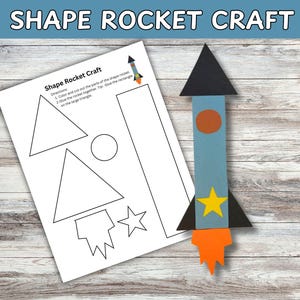 Könnte beinhalten: Eine fertige Papierrakete in Blau, Orange und Schwarz neben einem Arbeitsblatt mit Raketenumrissen. Die Rakete hat eine schwarze Dreiecksspitze, einen orangefarbenen Kreis und einen gelben Stern.