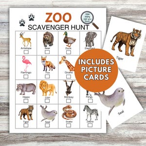 Op de afbeelding: Een Zoo Scavenger Hunt-spel met een checklist van dieren, waaronder een tijger, een zebra en een giraffe. Het spel bevat plaatjeskaarten en de tekst "Includes Picture Cards". Het spel staat op een witte achtergrond.