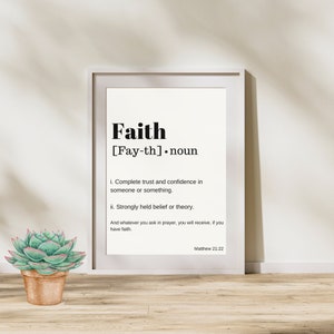 May include: A framed print with a white background and black text. The text defines the word "faith" as complete trust and confidence in someone or something, and strongly held belief or theory. The print also includes a quote from Matthew 21:22, "And whatever you ask in prayer, you will receive, if you have faith."
