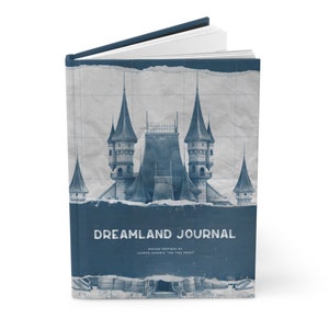 May include: A blue and white journal with a castle illustration on the cover. The text "DREAMLAND JOURNAL" is printed on the cover, along with the words "DESIGN INSPIRED BY LAUREN ASHER'S "THE FINE PRINT"".
