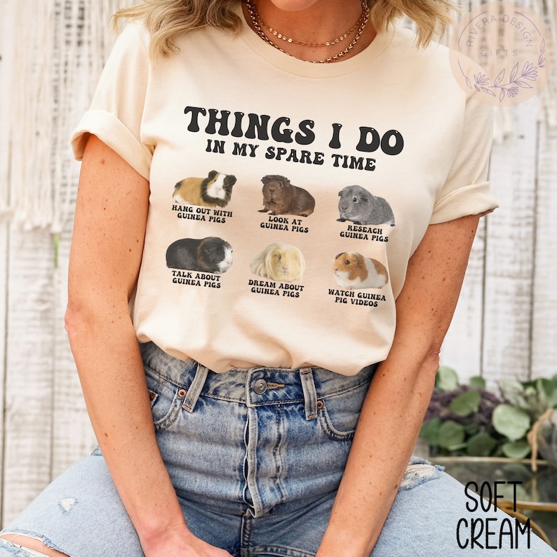 May include: A beige t-shirt with the text "Things I do in my spare time" and images of guinea pigs with text describing activities like "Hang out with guinea pigs", "Look at guinea pigs", "Research guinea pigs", "Talk about guinea pigs", "Dream about guinea pigs", and "Watch guinea pig videos".