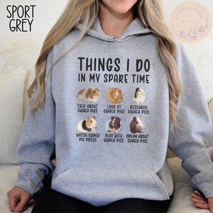 Pu&ograve; includere: Una felpa con cappuccio grigia con il testo "Things I do in my spare time" e sei immagini di porcellini d'India con didascalie che descrivono attivit&agrave; legate ai porcellini d'India.