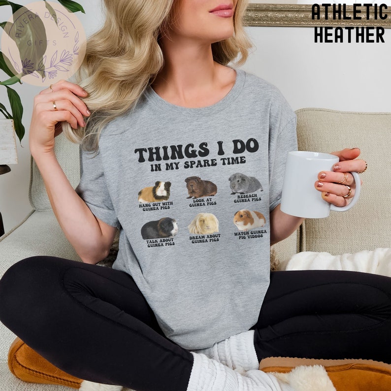 May include: A gray t-shirt with the text "Things I do in my spare time" and illustrations of guinea pigs. The text below the illustrations includes phrases like "Hang out with guinea pigs", "Look at guinea pigs", "Research guinea pigs", "Talk about guinea pigs", "Dream about guinea pigs", and "Watch guinea pig videos".
