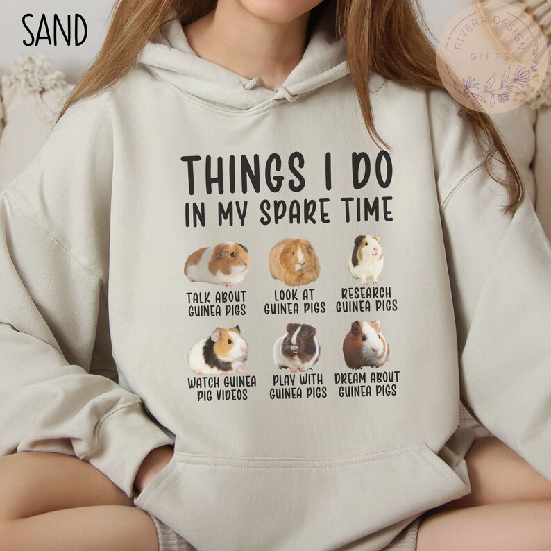 Pu&ograve; includere: Una felpa con cappuccio grigio chiaro con il testo "Things I do in my spare time" e immagini di porcellini d'India con didascalie che descrivono attivit&agrave; come "Parlare di porcellini d'India", "Guardare i porcellini d'India", "Ricercare i porcellini d'India", "Guardare video di porcellini d'India", "Giocare con i porcellini d'India" e "Sognare i porcellini d'India".