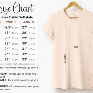 May include: Size chart for unisex t-shirts in softstyle fabric. The chart shows the width and length measurements in inches and centimeters for sizes XS to 3XL.  The chart also includes information about fitted, regular, relaxed, and oversized fits.