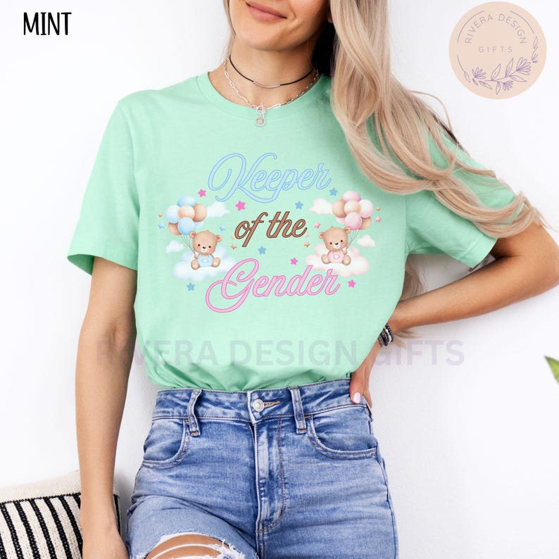 May include: A mint green t-shirt with the text "Keeper of the Gender" in pink and blue lettering. Two cartoon teddy bears are holding balloons, one blue and one pink, above the text.