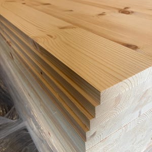 May include: A stack of unfinished, light brown wooden boards. The boards are stacked neatly and are ready for use in a variety of woodworking projects.