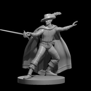 May include: A gray painted miniature figurine of a person wearing a feathered hat and a cape, holding a sword in their right hand.