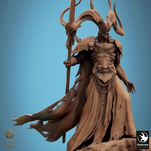 May include: A detailed sculpture of a demonic figure with large horns, a skeletal face, and a flowing robe. The figure holds a staff topped with a skull. The sculpture is in shades of brown and tan, with a blue background. The figure has a chain around its chest and skulls on its shoulders.