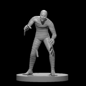 May include: A gray mummy figurine with a distressed, weathered look. The mummy is standing with its arms outstretched and its mouth open in a scream. The figurine is posed on a round base.