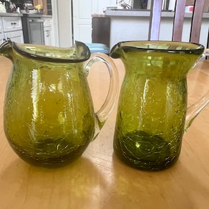 Un paio di brocche in vetro soffiato verde oliva effetto craquelé