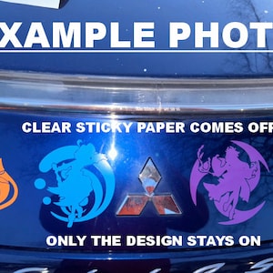 May include: Four different vinyl decals on a blue car. The decals are in the shapes of a star, a crescent moon, a circle, and a flame. The text "CLEAR STICKY PAPER COMES OFF" and "ONLY THE DESIGN STAYS ON" is visible on the car.