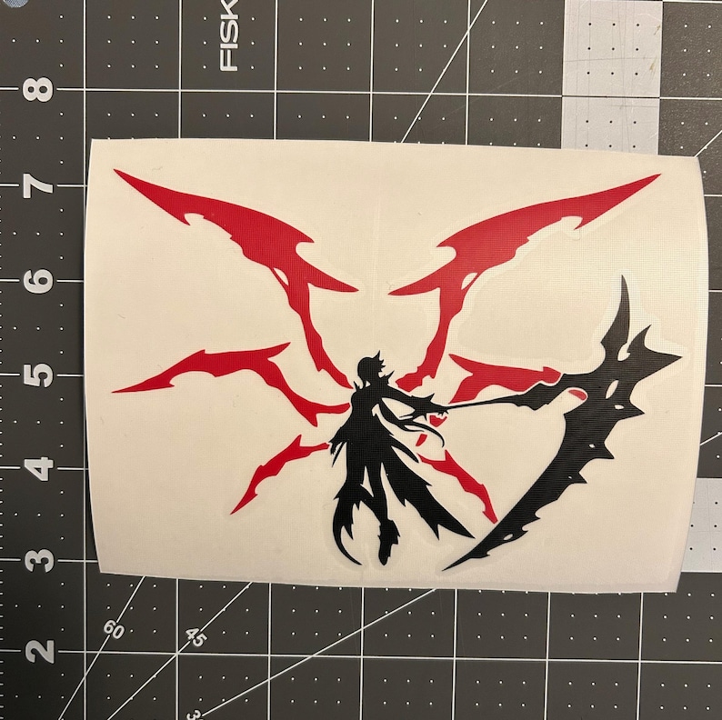 May include: Black and red vinyl decal of a stylised figure with long hair and a flowing cape holding a large scythe. The figure is surrounded by a red, spiky halo.