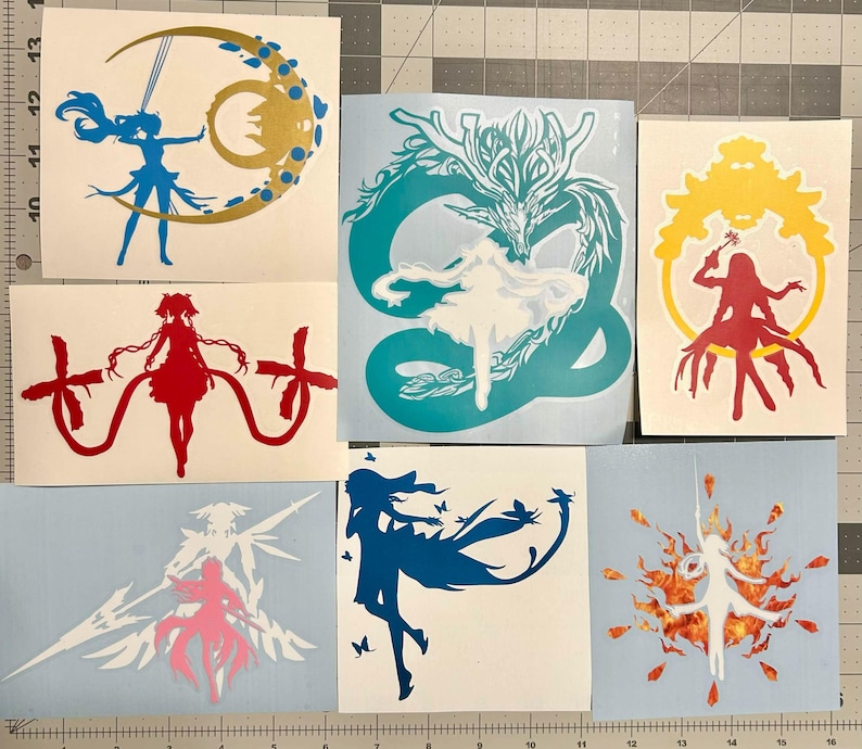 Puede incluir: Una colecci&oacute;n de siete pegatinas de vinilo con varias siluetas de estilo anime. Los dise&ntilde;os incluyen una figura azul con una luna creciente dorada, un drag&oacute;n verde azulado, un marco amarillo con una figura roja y otros personajes.