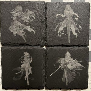 Puede incluir: Un juego de cuatro posavasos cuadrados de pizarra negra, cada uno con una ilustración grabada con láser de un personaje de estilo anime en una pose dinámica. Los posavasos tienen una textura de piedra natural rugosa y irregular.