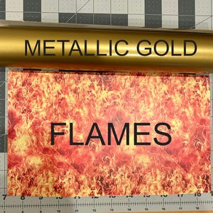 Puede incluir: Un rollo de vinilo adhesivo dorado met&aacute;lico colocado sobre una hoja rectangular con un estampado gr&aacute;fico vibrante y de alto contraste de llamas naranjas y amarillas. El texto METALLIC GOLD est&aacute; en el rollo y FLAMES en la hoja.