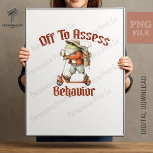 Könnte beinhalten: Ein rechteckiger Druck mit einem Frosch in beigem Hut, orangefarbener Jacke und Shorts, der auf einem orangefarbenen Roller fährt und einen Rucksack sowie einen Becher trägt. Der Text "Off To Assess" steht oben und "BEHAVIOR" unten in Rot.
