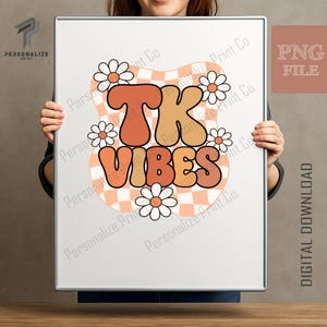 May include: A digital graphic print featuring the text TK VIBES in bold, rounded, orange and tan letters. The design includes a wavy, peach-colored checkerboard background and several white daisies with orange centers arranged around the text.