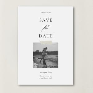 May include: A white card with the text "SAVE THE DATE" in elegant script. A black and white photo of a couple is taped to the card. The date "24 August 2025" and address are printed below the photo. Wedding announcement.