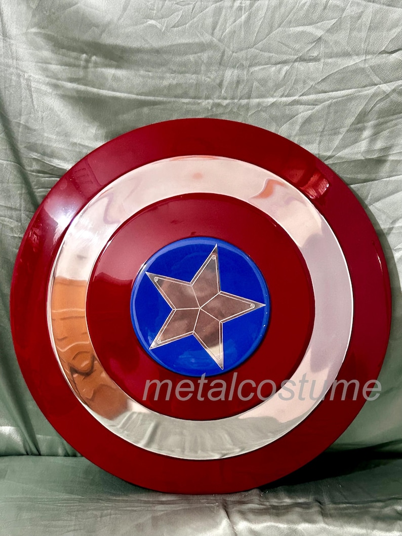 Op de afbeelding: Een rood, wit en blauw Captain America schild met een zilveren ster in het midden. Het schild is gemaakt van plastic en heeft een glanzende afwerking.