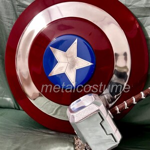 Op de afbeelding: Een rood, wit en blauw Captain America schild met een zilveren ster in het midden, en een zilveren Thor's hamer met een bruine handvat.
