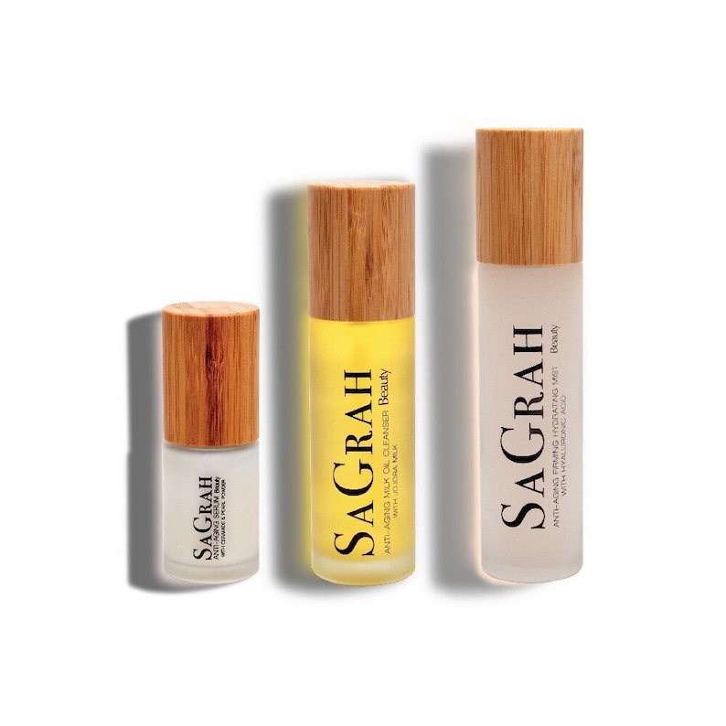 May include: Three glass bottles with bamboo lids and labels. The bottles contain a serum, a cleanser, and a hydrating mist. Each bottle has the brand name "SAGRAH" printed on the label.
