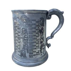 May include: A pewter tankard with a handle, featuring a timeline of British monarchs from Mary I to Elizabeth II, with their reign dates.