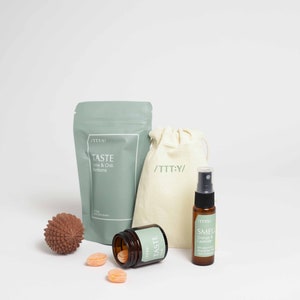 Könnte beinhalten: Ein Set mit Bad- und Körperpflegeprodukten in einem grün-weißen Farbschema. Das Set enthält eine Tüte mit Limetten- und Chili-Bonbons, eine Flasche mit Orangen- und Lavendel-Raumspray, ein kleines Glas mit Badesalz und eine kleine braune Kugel.