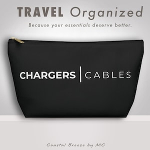 以下が含まれることがあります： 黒色のジッパー付きポーチ。白い文字で「CHARGERS | CABLES」と書かれています。ポーチの上には「TRAVEL Organized」、下には「Because your essentials deserve better.」と書かれています。ゴールドのジッパーと「Coastal Breeze by MC」も表示されています。