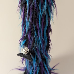 May include: A black glass water pipe with a blue and purple fuzzy exterior. The pipe has a black mouthpiece and a black base.