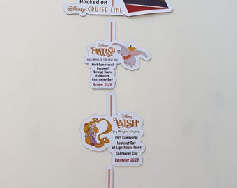 May include: A vertical image of three Disney Cruise Line magnets. The top magnet features a red, white and black cruise ship with the text "Hooked on Disney Cruise Line". The middle magnet features a white background with the text "Disney Fantasy" and a cartoon image of Dumbo. The bottom magnet features a white background with the text "Disney Wish" and a cartoon image of Rapunzel. The magnets are connected by a red rope with a brown anchor at the bottom.