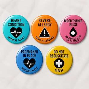May include: Five circular medical alert buttons in bright colors. The teal button reads HEART CONDITION MEDICAL ALERT. The orange button reads SEVERE ALLERGY AVOID ALLERGENS. The pink button reads BLOOD THINNER IN USE INCREASED RISK OF BLEEDING. The blue button reads PACEMAKER IN PLACE MEDICAL ALERT. The yellow button reads DO NOT RESUSCITATE DNR.