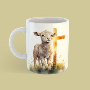 May include: White ceramic mug with a watercolor illustration of a lamb standing in front of a golden cross. The background is a watercolor wash of yellow and orange.