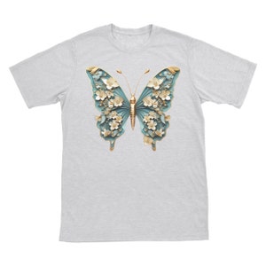 May include: A grey t-shirt featuring a blue and gold butterfly design. The butterfly is crafted from paper and has white flowers on its wings.