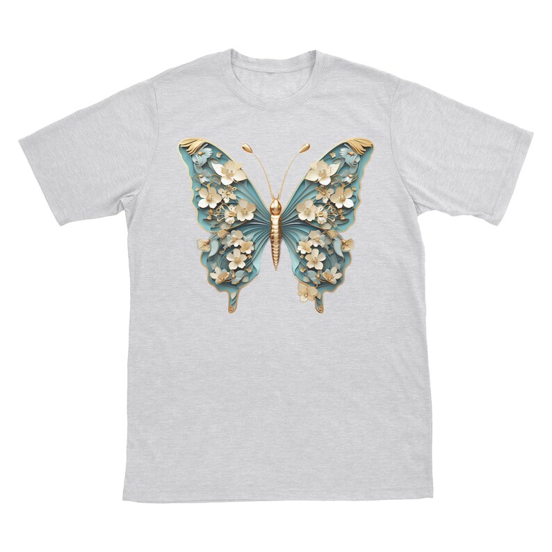 May include: A grey t-shirt featuring a blue and gold butterfly design. The butterfly is crafted from paper and has white flowers on its wings.