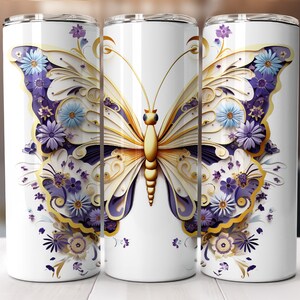 May include: White stainless steel tumbler featuring a gold and purple butterfly design. The butterfly has intricate details and is surrounded by flowers.