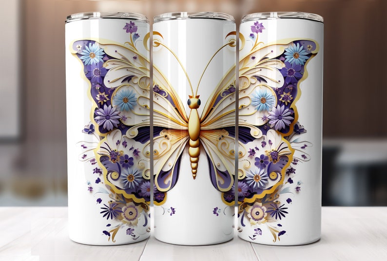 May include: White stainless steel tumbler featuring a gold and purple butterfly design. The butterfly has intricate details and is surrounded by flowers.