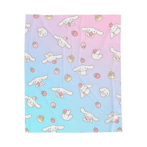 May include: A blanket with a repeating pattern of a white cartoon character with long ears, strawberries, and baskets of strawberries. The background has a gradient of blue and pink.