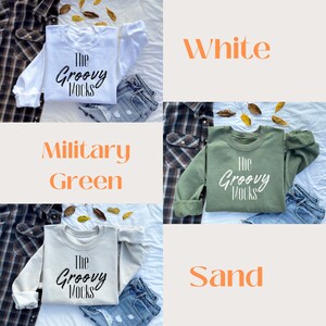 May include: Three sweatshirts in different colours: white, military green, and sand. Each sweatshirt has the text "The Groovy Mocks" printed on the front in black.