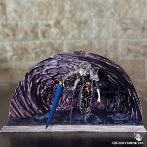 May include: A detailed figurine of a fantasy character, clad in silver armor and holding a blue sword with a gold hilt. The figure stands before a dark purple, textured backdrop. The base is dark blue and the overall theme is fantasy.