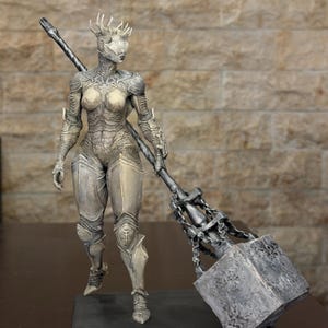 Könnte beinhalten: Eine detaillierte Figur eines humanoiden Kriegers in komplexer, verwitterter Rüstung mit einer Dornenkrone. Die Figur hält einen großen, schwer wirkenden Kriegshammer mit einem texturierten, metallischen Kopf und einem langen, gedrehten Stiel.
