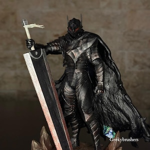 Puede incluir: Figura detallada de un guerrero con armadura negra, sosteniendo una gran espada y una bandera. La figura tiene un casco con cuernos y una capa fluida. La espada tiene un borde rojo. La figura está sobre una base rocosa.