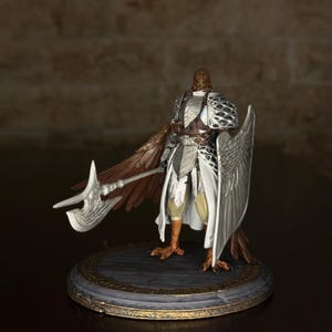 May include: A detailed figurine of a warrior with avian features, holding a silver axe and shield. The figure wears ornate armor with white and silver accents, brown wings, and bird-like feet. It stands on a circular base with gold trim, showcasing a fantasy theme.
